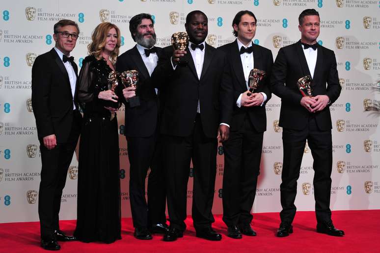 <p>Equipe do longa, liderada pelo diretor Steve McQueen (erguendo prêmio), posa para foto em Londres</p>
