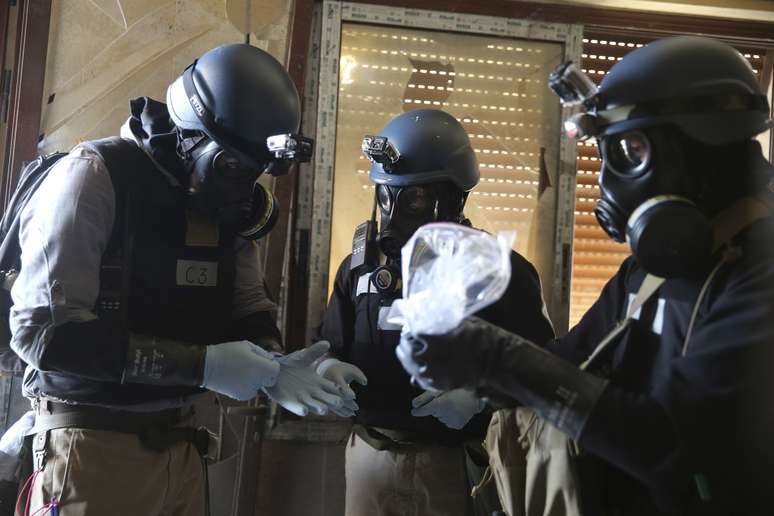 <p>Especialistas das Nações Unidas em armas químicas avaliam sacola plástica com amostras de um dos locais que sofreram um suposto ataque de armas químicas no bairro de Ain Tarma, em agosto de 2013</p>