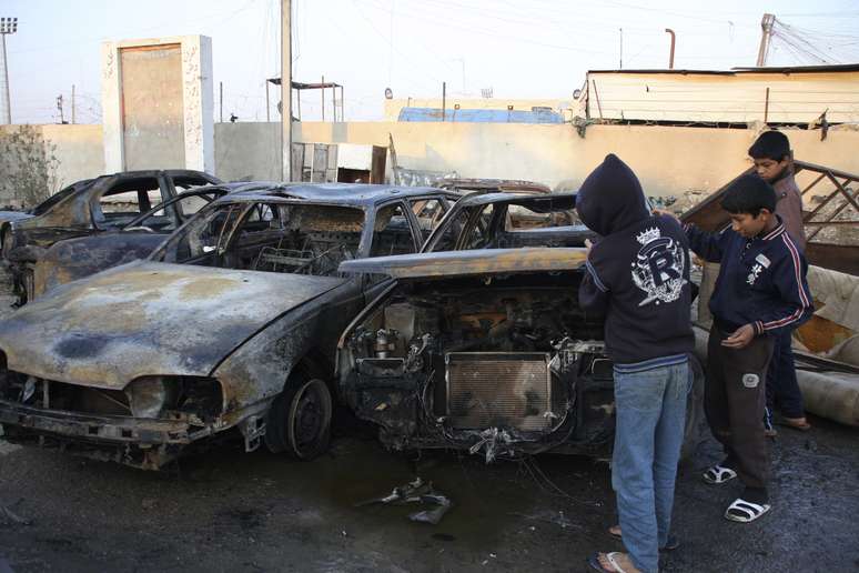 <p>Crian&ccedil;as observam local onde carros-bomba explodiram na capital Bagd&aacute;, nesta&nbsp;ter&ccedil;a-feira, 18</p>