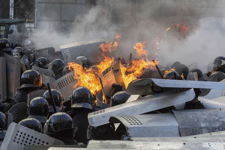 <p><strong>18 de fevereiro - </strong>Manifestantes jogam objetos contra o prédio do Ministério durante protestos nesta terça-feira</p>