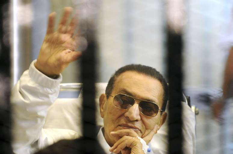 <p>Hosni Mubarak acena para apoiadores durante julgamento, em abril de 2013</p>