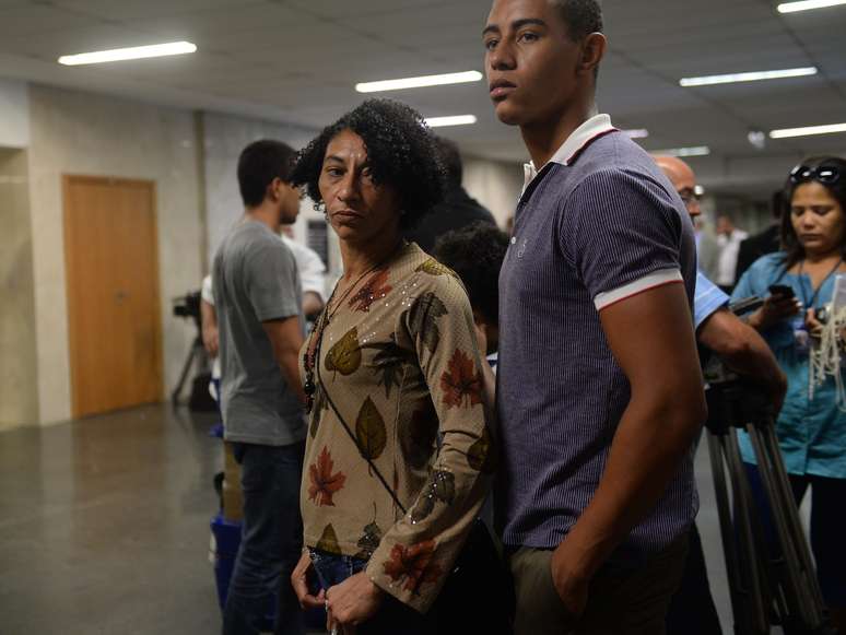 <p>Na primeira audiência, a mulher e o filho do ajudante de pedreiro chegam ao tribunal onde serão julgados os 25 acusados de terem torturado e assassinado Amarildo</p>