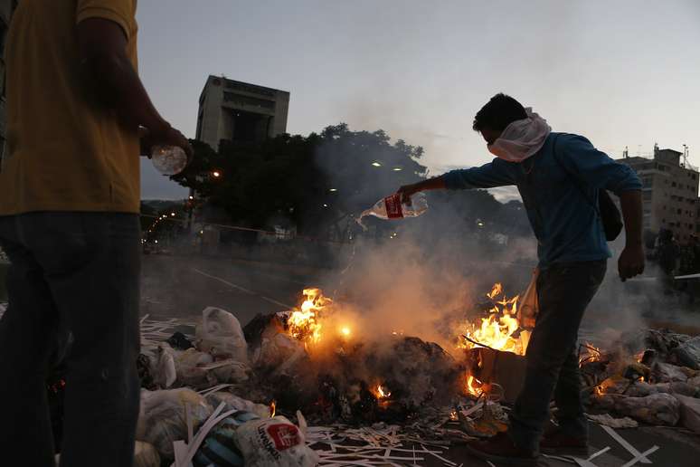 Manifestantes da oposição próximos a barricada, em Caracas