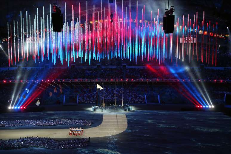 Luzes da russa iluminam estádio na chegada da bandeira nacional ao estádio