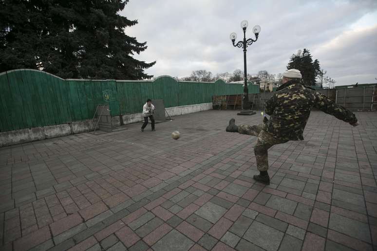 Manifestantes jogam futebol em frente a portão do Parlamento ucraniano