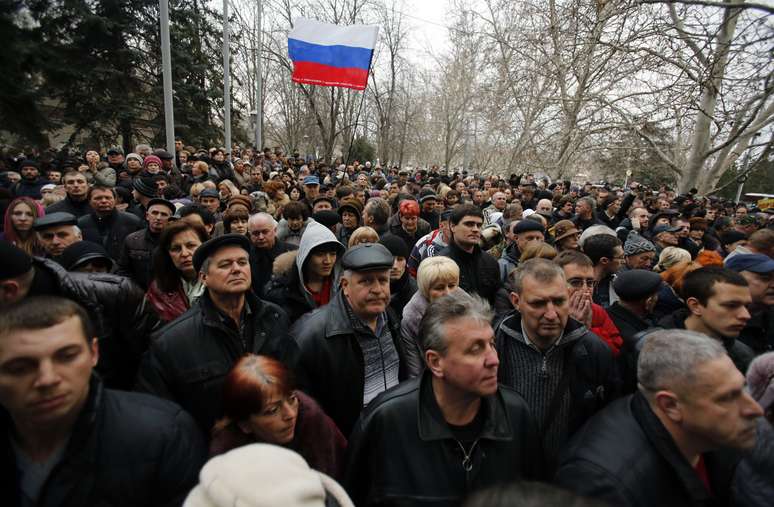 Manifestantes pro-Rússia erguem bandeira do país em frente à prefeitura do porto de Sebastopol, na península da Crimeia, em 24 de fevereiro