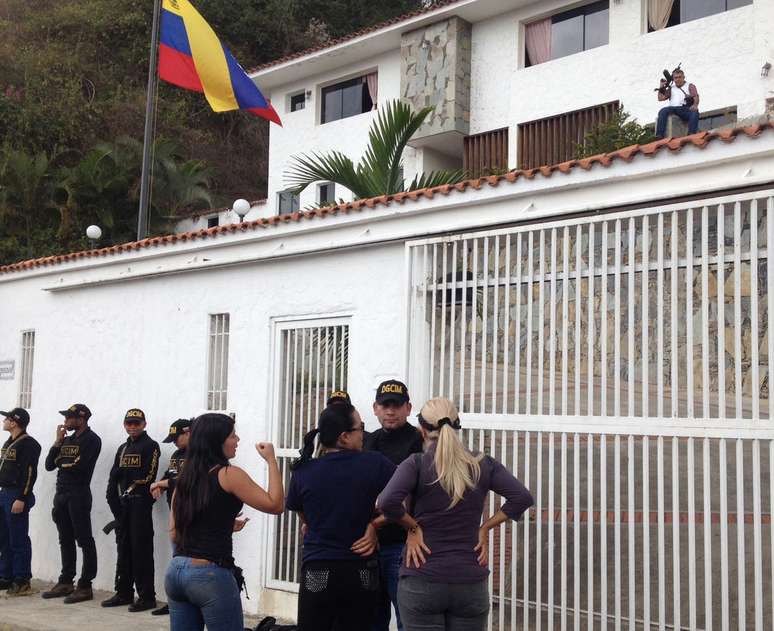 <p>Membros da Inteligência da Guarda Nacional da Venezuela em frente à casa do ex-general oposicionista Angel Vivas, enquanto ele espera armado, em 23 de fevereiro</p>