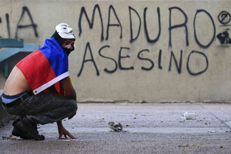 Manifestante faz uma pausa durante confronto com a polícia na Praça Altamira, em Caracas