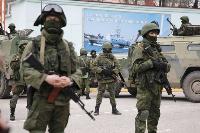 <p>Soldados armados, ao lado de veículos do exército russo, em frente a um posto de guarda de fronteira na cidade de Balaclava, na Crimeia, em 1 de março</p>