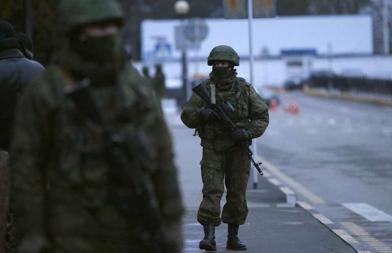 <p>Homens armados patrulham o aeroporto em Simferopol, na Crimeia, Ucr&acirc;nia, nesta sexta-feira</p>
