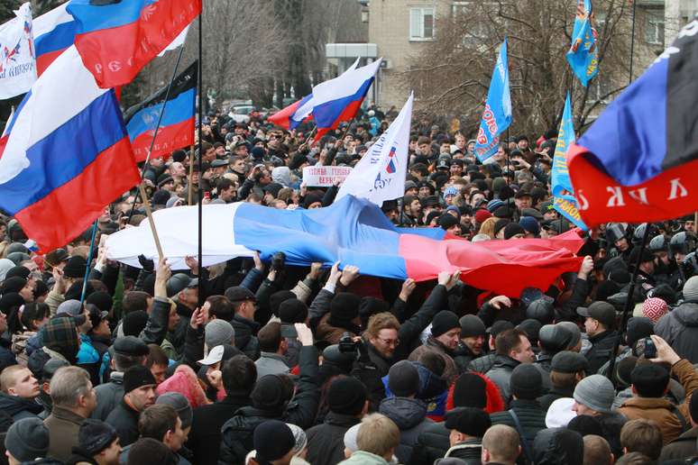 Manifestantes pró-Rússia seguram bandeiras do país durante protesto no centro de Donetsk, na Ucrânia, neste sábado, 1 de março