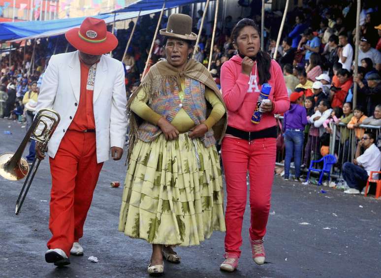 <p>Músicos caminham na cena de um acidente que deixou mortos e feridos pessoas depois que uma passarela de metal despencou em Oruro, na Bolívia, em 1 de março. As autoridades bolivianas disseram que 4 morreram e mais de 70 se feriram no acidente</p>