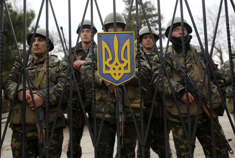 <p>Soldados ucranianos protegem entrada de base da infantaria enquanto tropas russas chegam na regi&atilde;o</p>