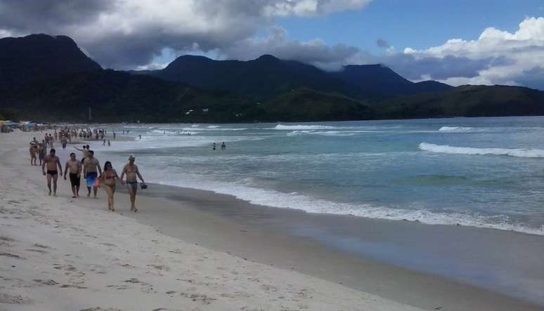 <p>De acordo com a Climatempo, o dia ser&aacute; de&nbsp;c&eacute;u nublado nesta segunda-feira no litoral paulista; na foto, banhistas caminham por praia de Maresias</p>