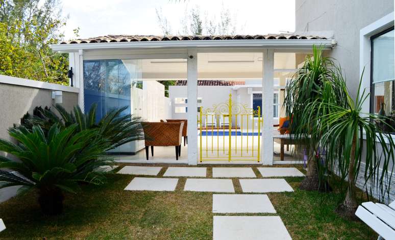 Esta casa no bairro de Camboinhas, em Niterói, foi repaginada para que os moradores pudessem receber amigos na área externa. O paisagismo do jardim foi refeito, e o antigo portãozinho que o separa da área de lazer foi restaurado