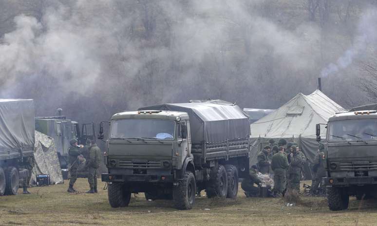 Grupo de militares armados permanece próximo a um acesso à base militar de Perevalnoye, nos arredores de Simferopol, na Crimeia, em 7 de março