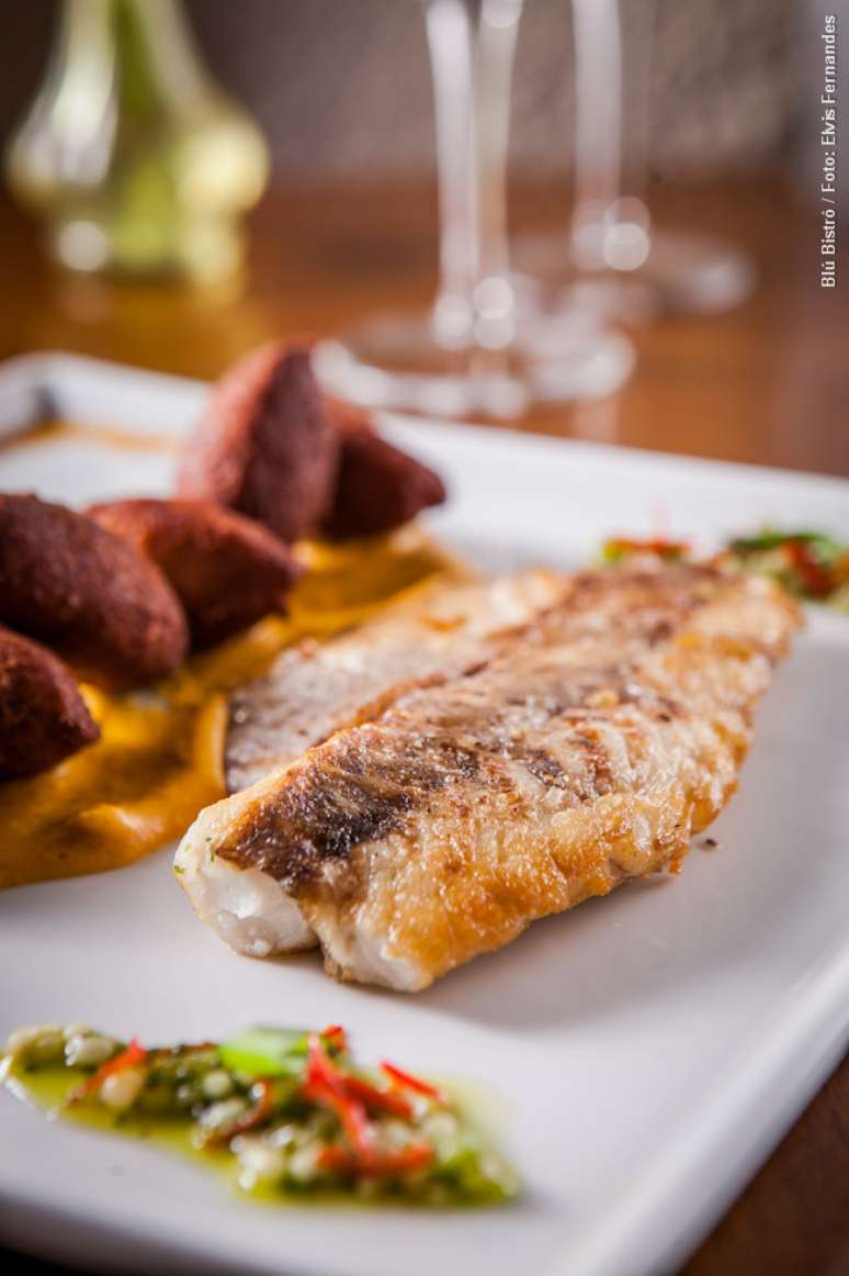Blú Bistrô serve Pescada dos Santos: pescada do Sul grelhada com vatapá, mini acarajés, vinagrete de tomate verde e caviar de quiabo