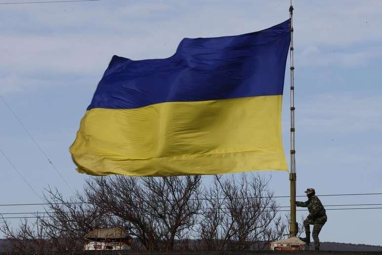 <p>Soldado ucraniano perto de uma bandeira na base A2904 na cidade de Bakhchisaray, na Crimeia (imagem de arquivo)</p>