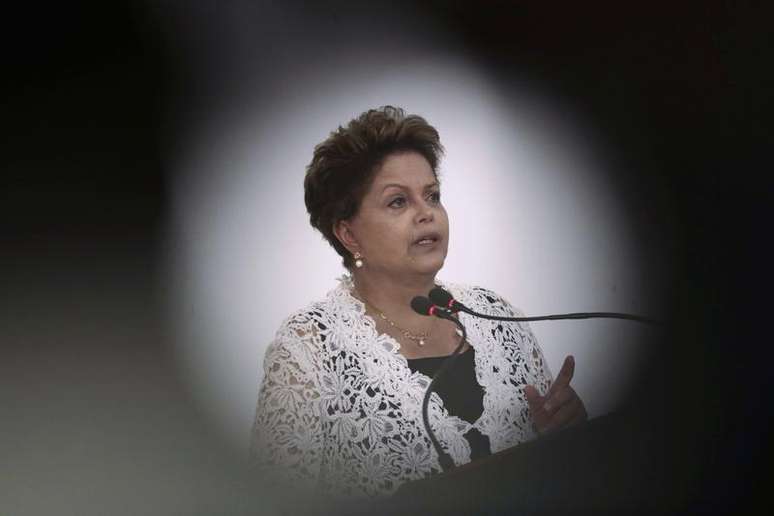 A presidente Dilma Rousseff fala durante uma cerimônia da assinatura de contratos de concessão da duplicação de rodovias em diversos Estados, no Palácio do Planalto em Brasília. Dilma anunciou nesta quinta-feira investimento de 3,8 bilhões de reais em obras de mobilidade urbana em seis Estados e no Distrito Federal, para tentar recuperar um atraso recebido como "herança" devido à falta de projetos no passado. 12/03/2014