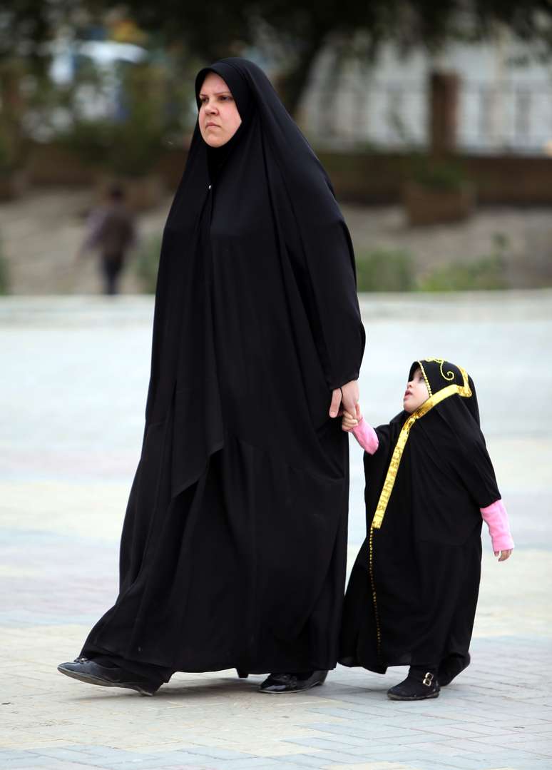 Mulher iraquiana anda com sua filha em Bagdá, nesta terça-feira, 18 de março, enquanto país discute casamento infantil