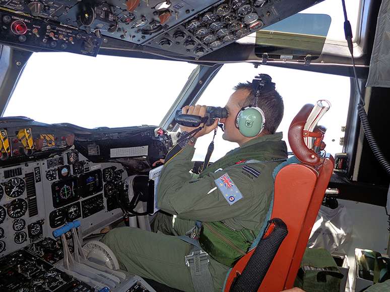 <p>Piloto da Força Aérea Real Australiana, a bordo de uma aeronave de patrulha marítima, varre a superfície do mar, perto do oeste da Península da Malásia, em 17 de março</p>