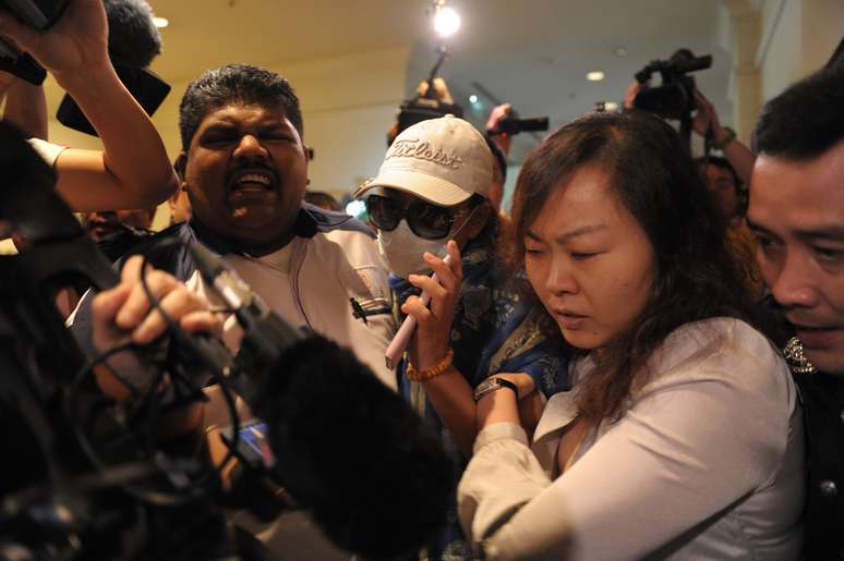 <p>Parentes chineses de passageiros do vôo desaparecido da Malaysia Airlines são bloqueados pela polícia da Malásia de entrar no centro de imprensa antes do início de uma entrevista  em um hotel perto do aeroporto intenracional de Kuala Lumpur, nesta quarta-feira, 19 de março</p>