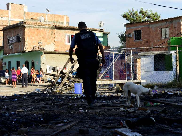 <p>Policial patrulha rua de favela em meio ao recrudescimento do conflito no Rio de Janeiro</p>
