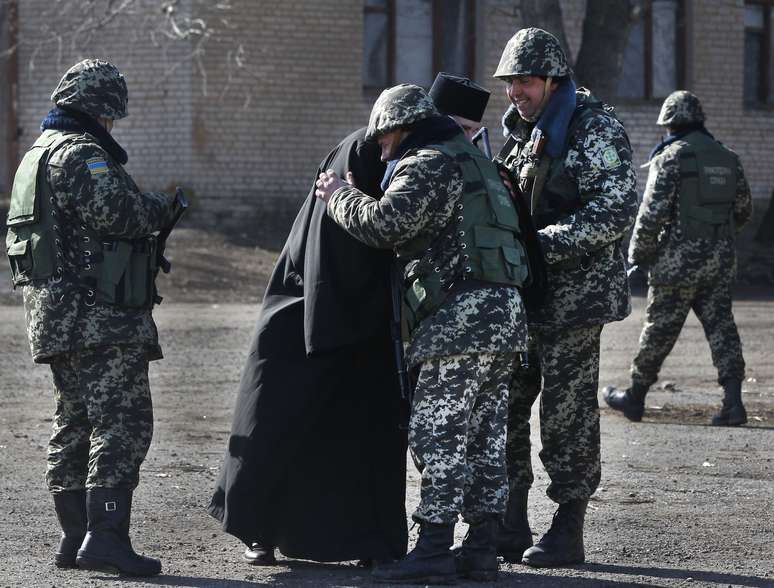 Soldados recebem um religioso na base militar de Alekseyevka, na fronteira entre a Ucrânia e a Crimeia