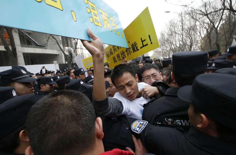 <p>Membros de família de passageiros a bordo do avião da Malaysia Airlines protestaram em Pequim, nesta terça-feira. Policiais tentaram conter protesto perto do Hotel Lido</p>