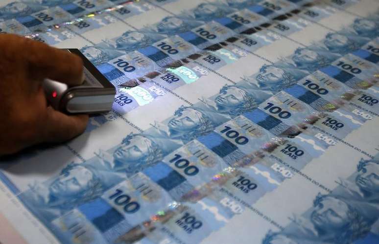 Funcionário verifica folhas de papel-moeda durante uma visita da mídia à Casa da Moeda, no Rio de Janeiro. O Banco Central manteve em 13 por cento a previsão de expansão do estoque total de crédito em 2014, de acordo com o chefe do Departamento Econômico do BC, Tulio Maciel, nesta quarta-feira. 23/08/2012