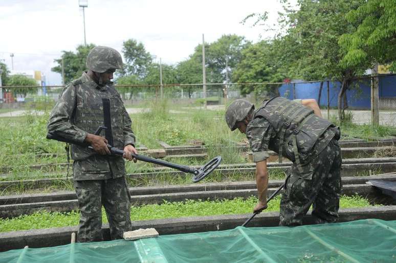 Equipes do Exército buscam armas e munições enterradas por traficantes na favela Nova Holanda, no Complexo da Maré