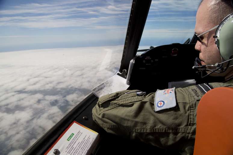<p>Oficial olha para fora do cockpit de um avi&atilde;o da For&ccedil;a A&eacute;rea australiana, enquanto busca pelo voo MH370 da Malaysian Airlines&nbsp;sobre o Oceano &Iacute;ndico meridional,&nbsp;em 27 de mar&ccedil;o</p>