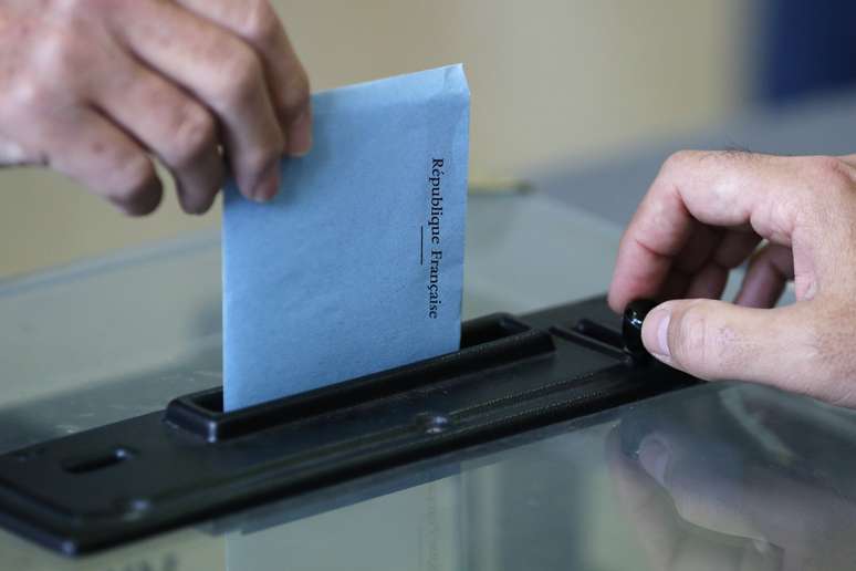 <p>Cidad&atilde;o franc&ecirc;s deposita seu voto na urna, no segundo turno das elei&ccedil;&otilde;es municipais em Nantes, neste domingo, 30 de mar&ccedil;o</p>