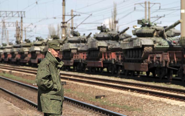 <p>Soldado russo perto de tanques ucranianos em vagões de carga, antes da partida da Crimea para outras regiões da Ucrânia, perto da cidade de Simferopol, em 31 de março</p>