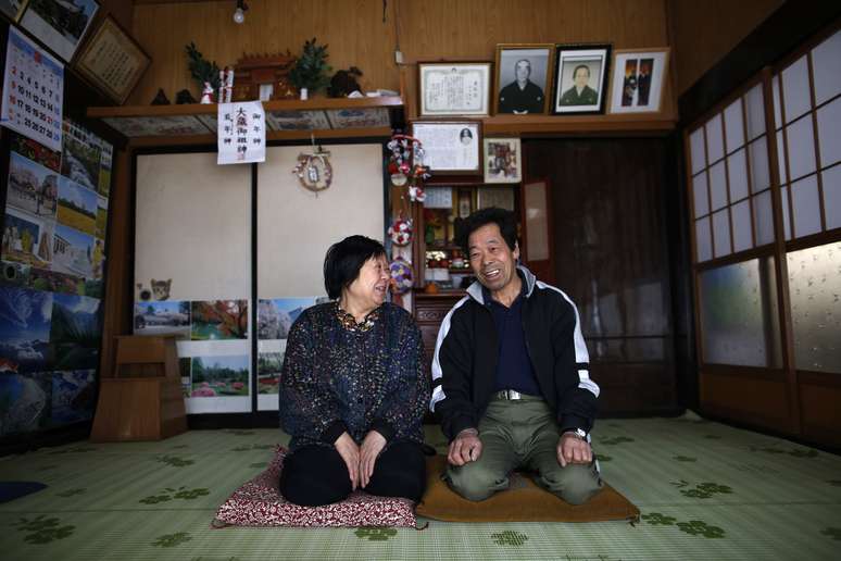 <p>Toshio Koyama, 72, e sua esposa, Kimiko, 69, que evacuaram o bairro de Miyakoji, em Tamura, há três anos, sorriem depois de voltarem para sua casa em Tamura, Fukushima, nesta terça-feira, 1 de abril</p>
