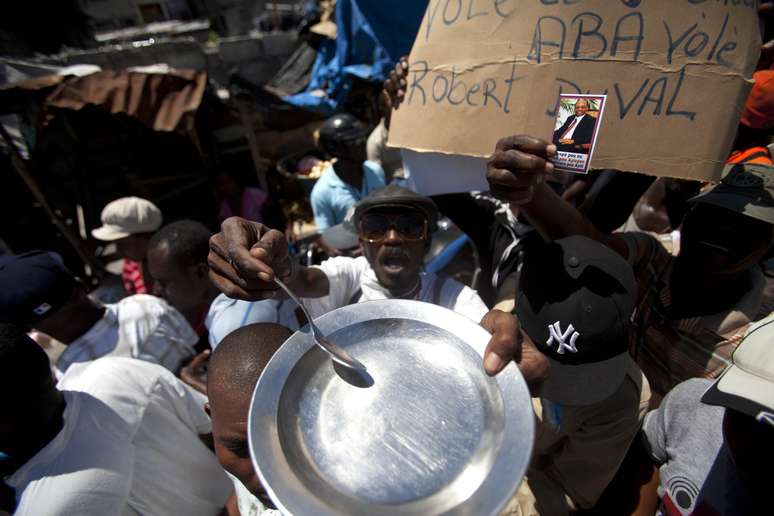 <p>Manifestante protesta contra a miséria no Haiti, em 29 de março de 2014. A população haitiana pede a renúncia do autal presidente, Michel Martelly, acusado de não tomar as medidas necessárias para cessar a fome no país</p>