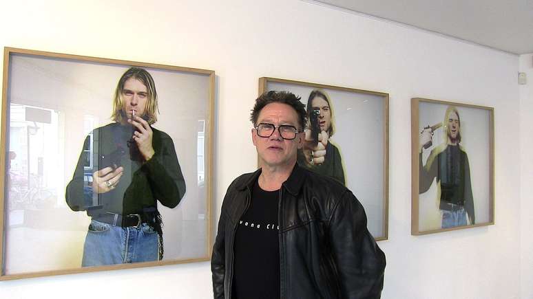 <p>Youri Lenquette em frente a imagem que faz parte da exposi&ccedil;&atilde;o que acontece em Paris</p>