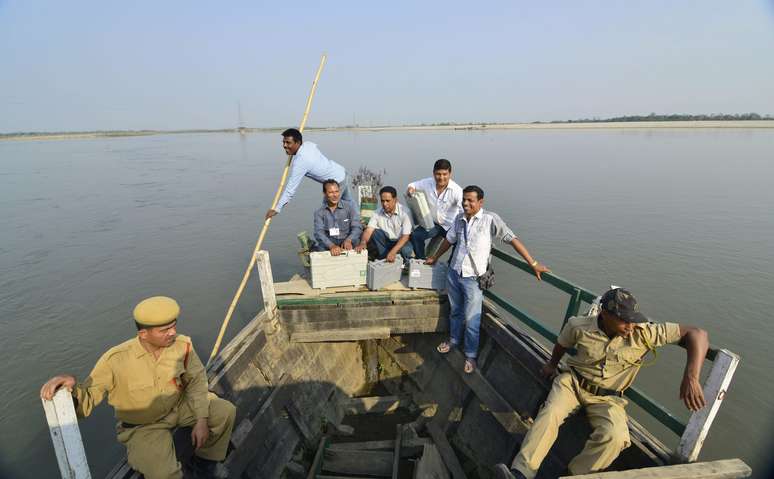 <p>Afegãos que trabalham nas eleições gerais de 2014 atravessa o rio Subansiri em um barco para levar as urnas eletrônicas a zonas de votação remotas do distrito de Lakhimpur, em 06 de abril</p>