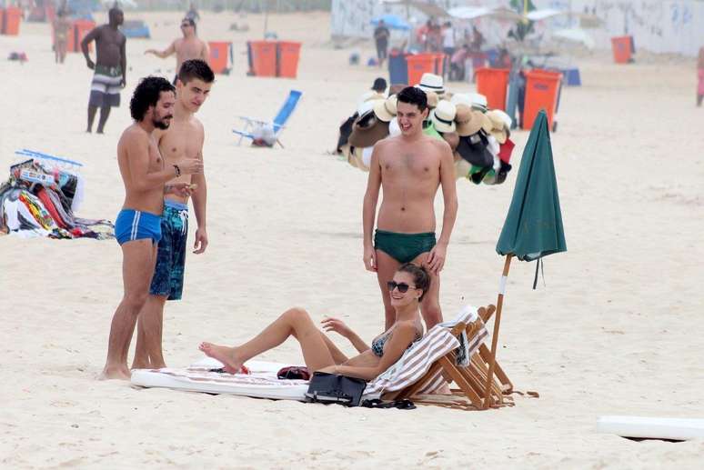 A modelo Carol Francischini, que desfilou nesta terça-feira (8) para a grife Patrícia Viera no Fashion Rio, curtiu praia em Ipanema nesta quarta-feira (9) ao lado de três homens