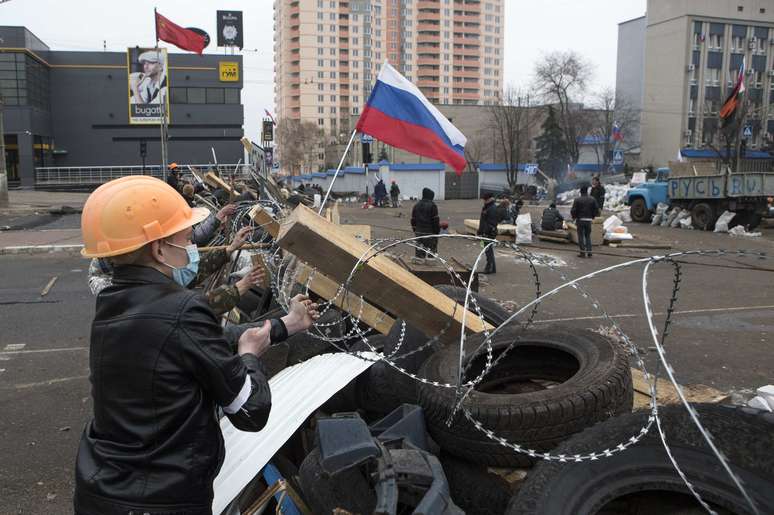Manifestante reforça barricada em prédio ocupado na cidade de Lugansk, no leste do país