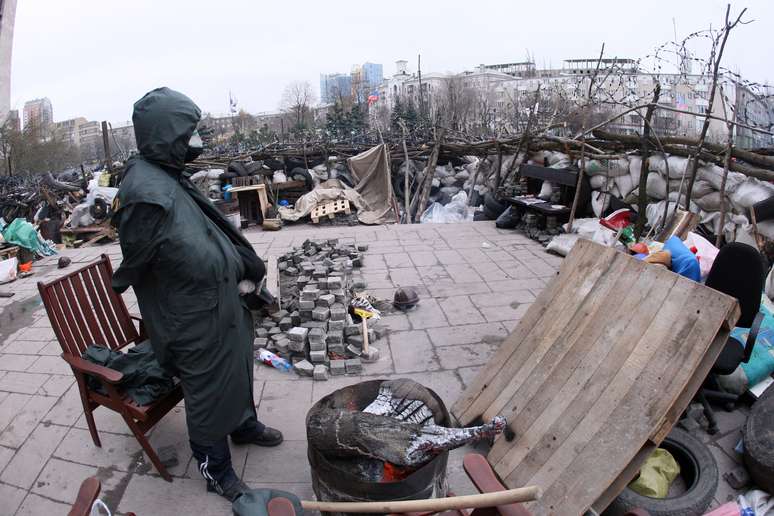 <p>Manifestante pr&oacute;-R&uacute;ssia guarda uma barricada em frente ao pr&eacute;dio da administra&ccedil;&atilde;o p&uacute;blica regional, em Donetsk, na Ucr&acirc;nia, em 11 abril</p>