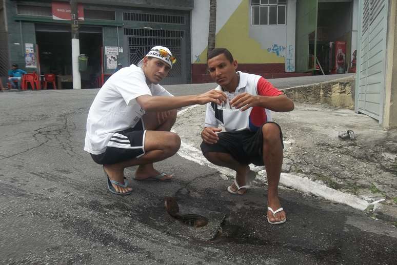 <p>Moradores fazem "brinde" em protesto pelo vazamento de água </p>