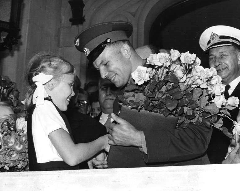 <p>11 de julho de 1961: o primeiro cosmonauta do mundo, Yuri Gagarin, da União Soviética recebe um buquê de flores de uma menina na chegada na embaixada soviética em Londres - um dia antes da viagem</p>
