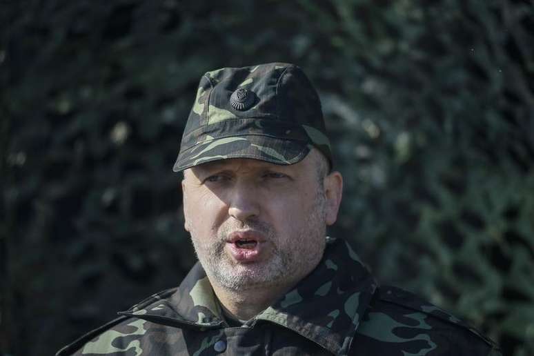 <p>Presidente ucraniano em exerc&iacute;cio, Oleksander Turchinov, ao falar com jornalistas durante um exerc&iacute;cio militar pr&oacute;ximo &agrave; vila de Goncharisvske, nesta segunda-feira, 14 de abril</p>