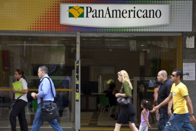 Pedestres passam em frente a uma unidade do Banco Pan Americano em São Paulo