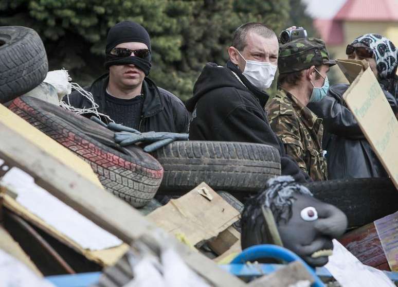 Manifestantes pró-Rússia com máscaras guardam uma barricada na frente do escritório do serviço de segurança SBU, tomado por eles, em Luhansk, no leste da Ucrânia. Habitantes russófonos do leste da Ucrânia mentiram ao se dizerem sob ataque, na tentativa de justificar um envolvimento da Rússia na atual crise, disse um relatório de direitos humanos da ONU divulgado na terça-feira. 15/04/2014