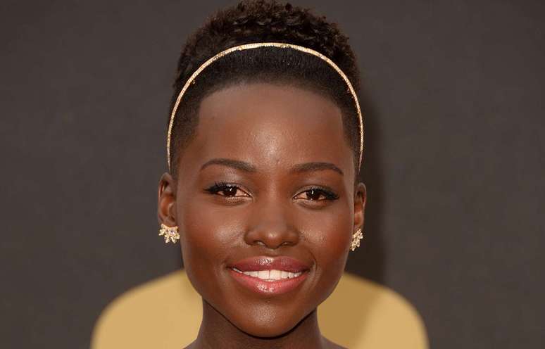 Lupita foi ao Oscar com a pele bem trabalhada, com poucos sinais de maquiagem, explica Anna. Esse efeito é obtido com uma base leve de acabamento translúcido. Nas maçãs, blush alaranjado (ótimo para peles negras), e iluminador suave no centro da testa e no queixo. Nos olhos, delineador marcado, do meio dos olhos para fora, máscara de cílios e batom rosado bem suave arrematado com gloss transparente.