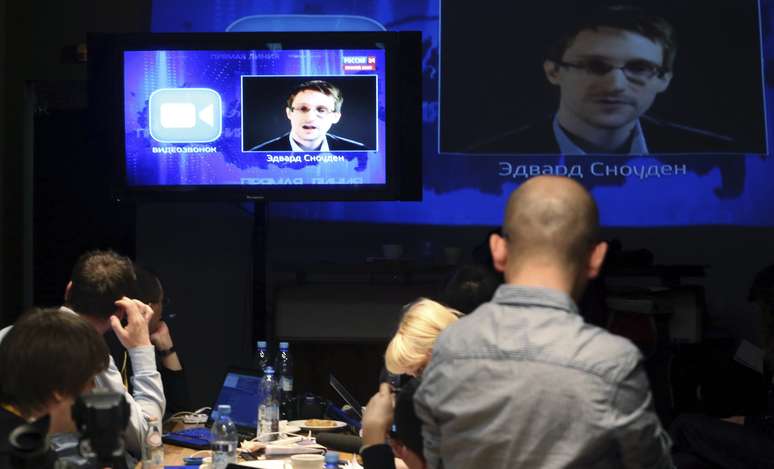 <p>Jornalistas ouvem&nbsp;a quest&atilde;o colocada por Edward Snowden, em um centro de m&iacute;dia, durante a sess&atilde;o&nbsp;ao vivo de perguntas e respostas do presidente russo, Vladimir Putin, em Moscou, nesta quinta-feira,&nbsp;17 de abril</p>