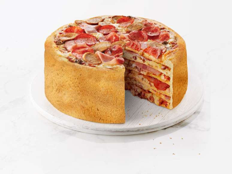 <p>Uma rede canadense de pizzarias espera adicionar um item inusitado ao seu menu: um bolo de pizza, feito com cinco camadas de massa, queijo e outros recheios</p>
