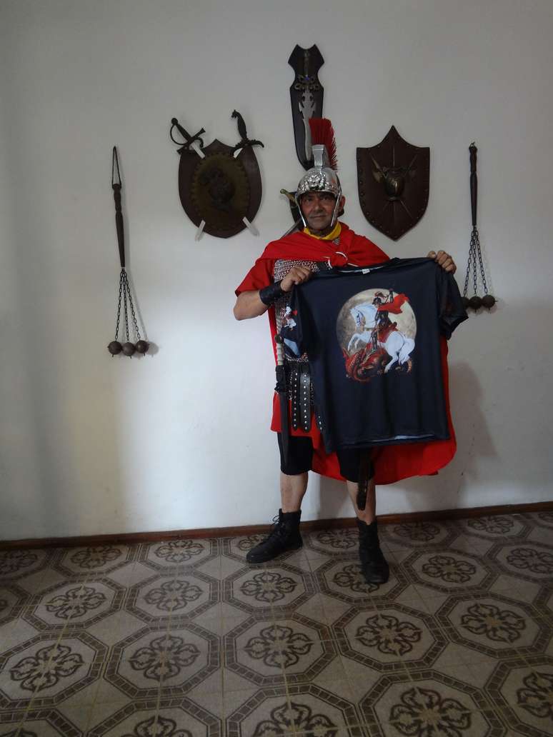O visual do devoto prima pelos detalhes, com direito a armadura, t&uacute;nica, espada e o elmo na cabe&ccedil;a